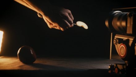Hands of a person holding a slice of apple in front of a camera